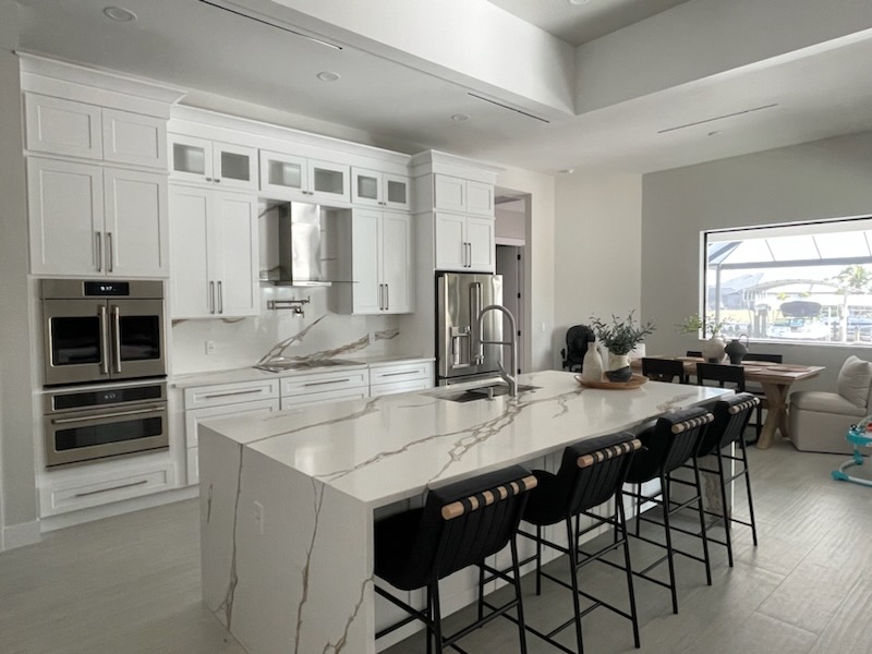 Modern white kitchen remodel with marble waterfall island